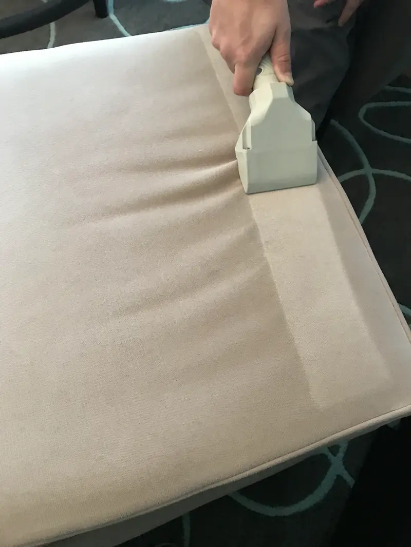An upholstery tool drawing a clean stripe across a cushion