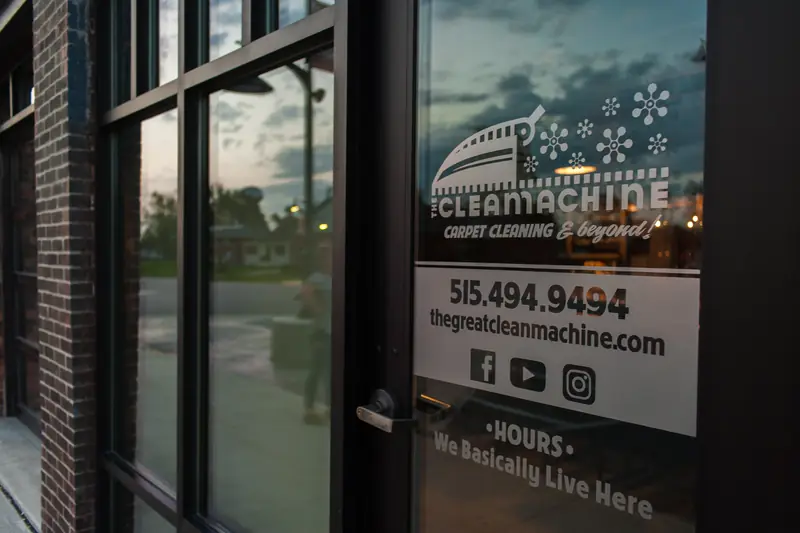 The shop door, lettered with the logo, the phone number and "Hours: we basically live here"