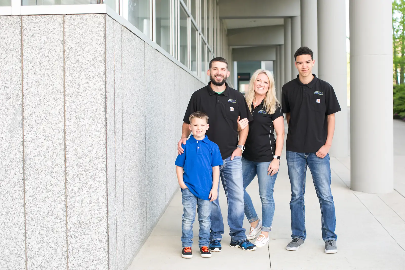 The Terhaar family, Russ, Mel and their two sons, outside a stone building