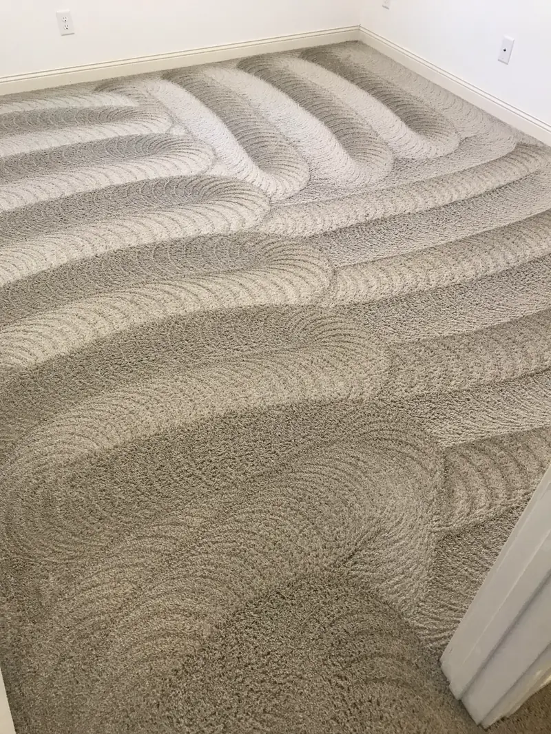 Scalloped wand marks across a cleaned carpet